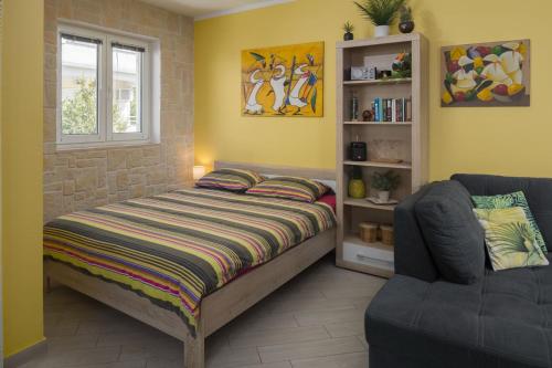a bedroom with a bed and a couch at Apartment Lemon & Soul in Selce