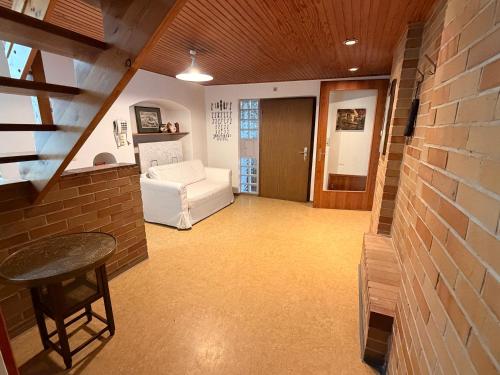 a living room with a white couch and a brick wall at Donau Apartment in Sinzing