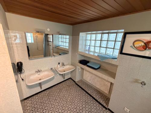 a bathroom with two sinks and a mirror at Donau Apartment in Sinzing