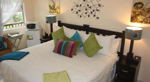 Un dormitorio con una gran cama blanca con almohadas. en Tariman Hotel, en Durban