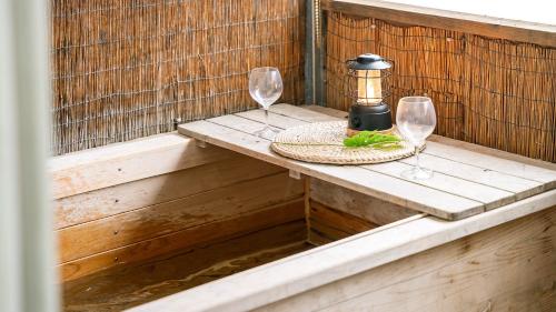 a table with two wine glasses and a lantern at Gapyeong Haneuldari pet pension in Gapyeong