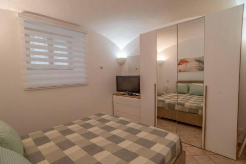 a small bedroom with a bed and a television at Apartment Sole e Luna - Fronte Mare in Nettuno