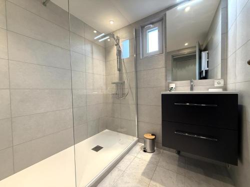 a bathroom with a shower and a tub and a sink at Beratarbide in Laroin