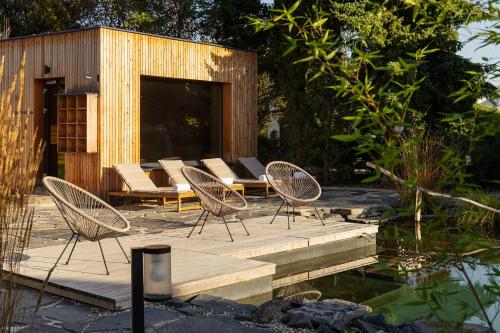 a group of chairs sitting on a patio next to a pond at Resort po.spolu in Mokrovraty