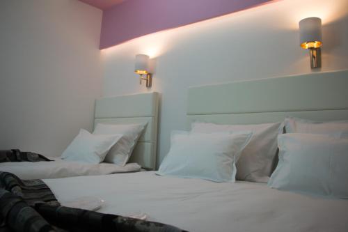 a bedroom with two beds with white pillows at Rooms Villa Downtown in Mostar