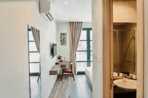 a bathroom with a sink and a desk and a bed at The Happy Marina Hotel Phú Quốc - Sunset & Ocean View in Phú Quốc