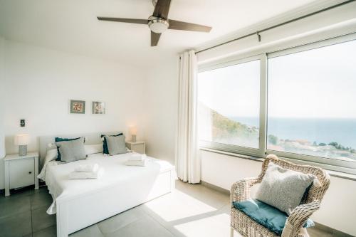 a living room with a bed and a large window at Villa Donna Cà con vista mare e piscina privata in Coccorino