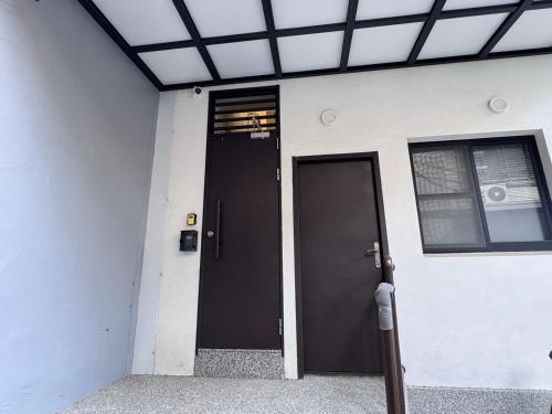 a building with a black door and a window at 星爍民宿 in Ch'ih-k'an-lou
