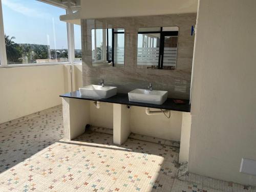 a bathroom with two sinks and a mirror at Hotel V Stay in Chennai