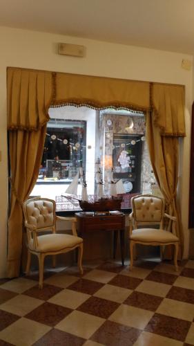 a room with a desk and two chairs and a window at Albergo Casa Peron in Venice