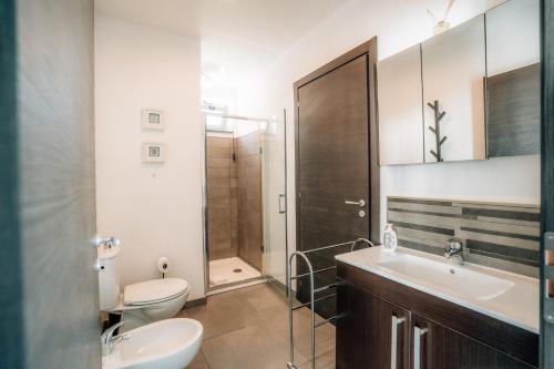 a bathroom with a toilet and a sink and a shower at Villa Donna Cà con vista mare e piscina privata in Coccorino
