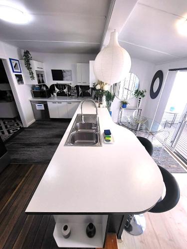 a kitchen with a white counter top and a sink at Eleda House - Retro Hidden Gem in Cessnock