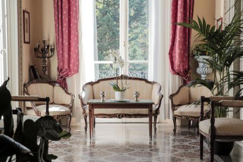 a living room with two chairs and a table and a window at Hotel Villa Liana in Florence