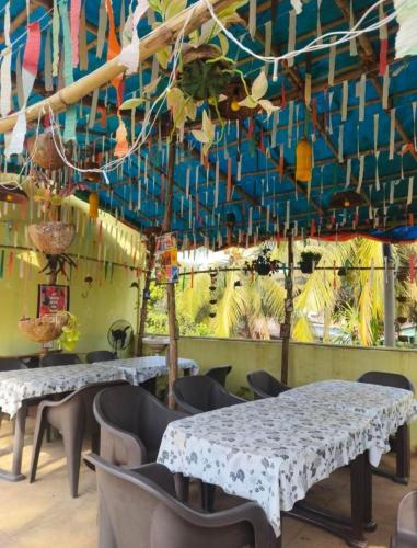 a dining room with two tables and chairs and a mural at Bageecha B&B-Jal in Alibaug
