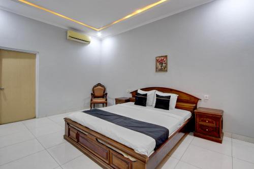 a bedroom with a large bed with a wooden frame at OYO 3934 Hotel Istana in Pekalongan