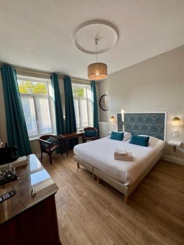 a bedroom with a large bed with blue curtains at Enclos de l'Evêché in Boulogne-sur-Mer
