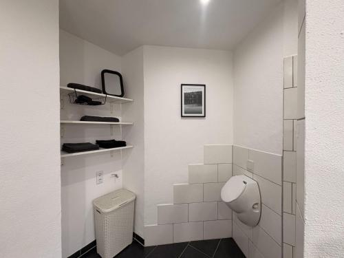 a white bathroom with a toilet and a mirror at Ferienwohnung "Zum Pfadfinder" in Thalfang