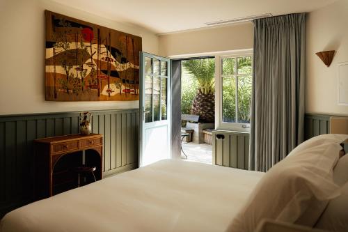 a bedroom with a bed and a door to a patio at La Maison du Bassin in Cap-Ferret