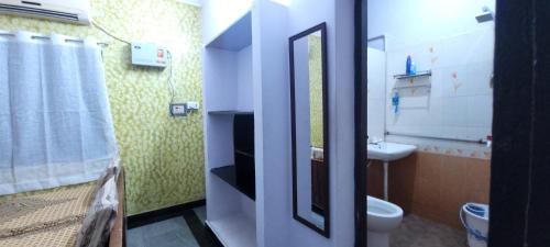 a small bathroom with a toilet and a sink at Uthamar Illam in Tiruchirappalli