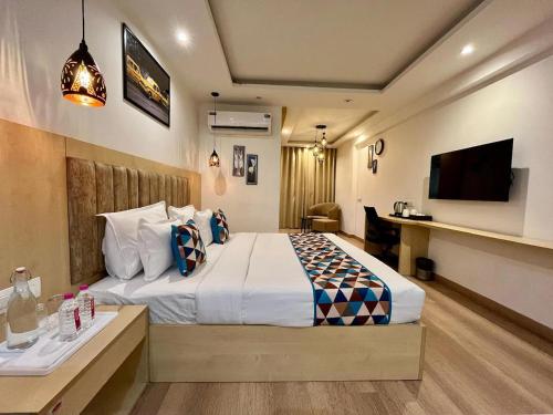 a hotel room with a bed and a flat screen tv at The Grand Anukampa in Jaipur