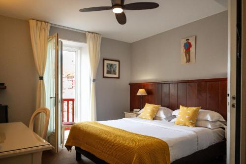 a bedroom with a bed and a ceiling fan at Hotel Les Almadies - Coeur de Ville in Saint-Jean-de-Luz