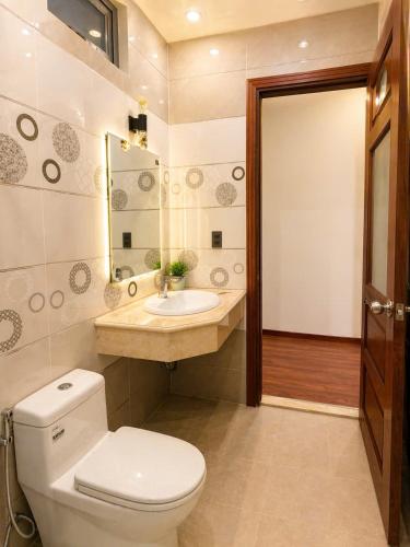 a bathroom with a toilet and a sink and a mirror at Nguyên căn villa Đà Lạt in Da Lat