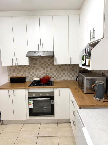 a kitchen with white cabinets and a stove top oven at Sonique-Uniqueness Crib in Cape Town