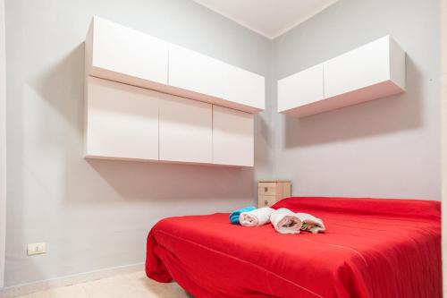 a bedroom with a red bed with white cabinets at Casa nel Borgo in Campomarino