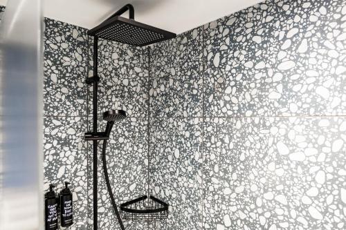 a bathroom with a shower with a tile wall at Village Hotel Solihull in Solihull