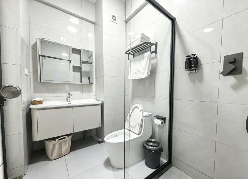 a white bathroom with a toilet and a sink at Ucha Hotel & Suites in Kampala