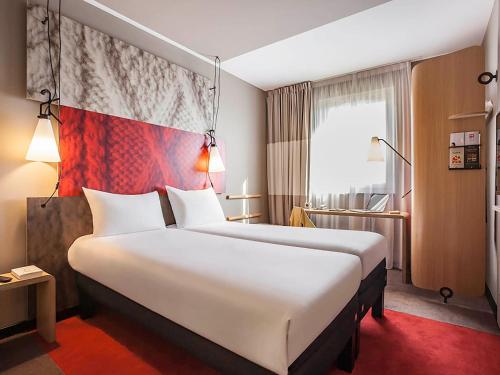 una habitación de hotel con una cama grande y una bandera en ibis Sens, en Sens