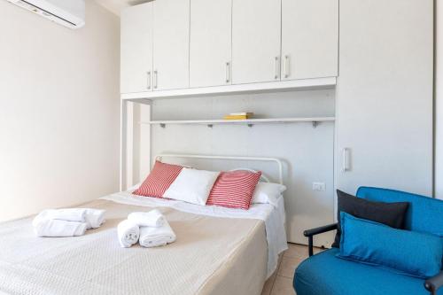 a bedroom with two beds and a blue chair at Italian Experience-Suite Riviera in Porto Recanati