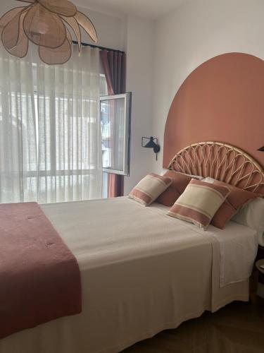 a bedroom with a large bed with a large window at Sol de Zafra Estudio in Zafra