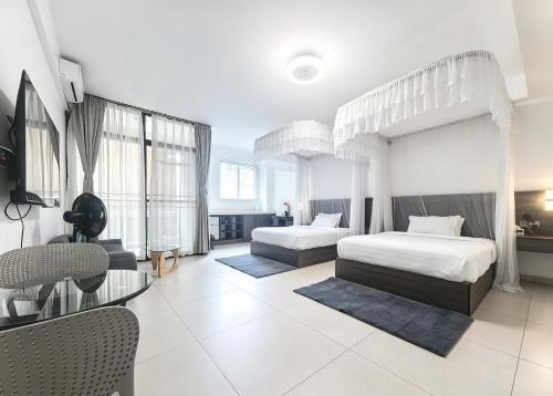 a bedroom with two beds and a table and chairs at Ucha Hotel & Suites in Kampala
