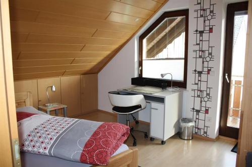 a bedroom with a bed and a desk and a sink at Ferienwohnung Traudel in Hatzenbühl
