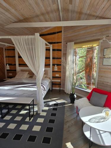a bedroom with a bed with a canopy at Treehouse Čiekurs in Duķuri