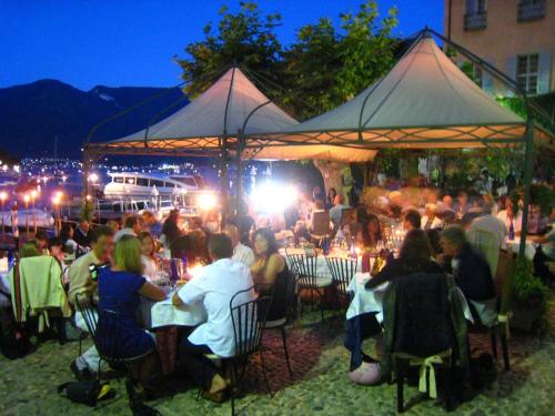 a group of people sitting at tables under a tent at Casa Lia Family-Friendly Holiday Home in Sala Comacina