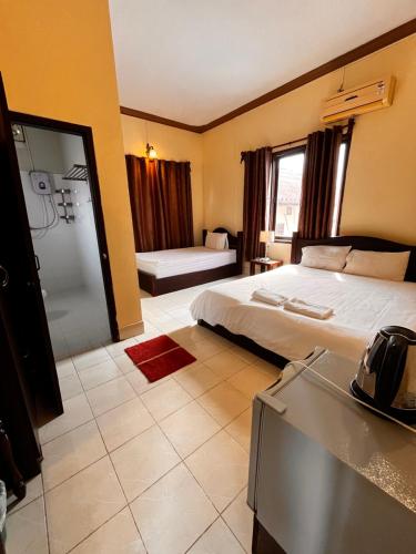 a hotel room with a bed and a bathroom at Camellia Hotel in Vang Vieng