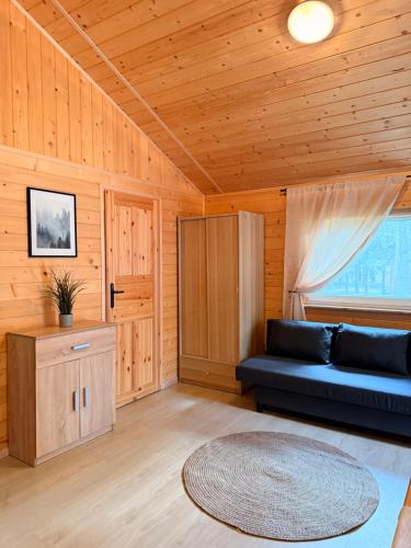 a living room with a couch and a table at Domki nad Firlejem in Firlej
