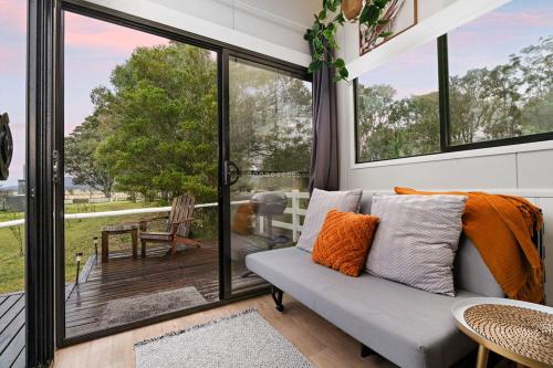 a living room with a couch and a sliding glass door at Yellow Rock Views by Tiny Away in Broke