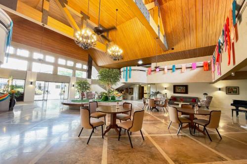 a lobby with tables and chairs in a building at Maharajah Hotel Angeles City in Angeles