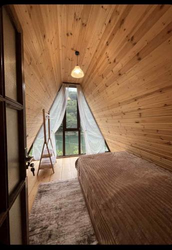a bedroom with a bed in a wooden room at LUNEA cottage in Machakhlispiri