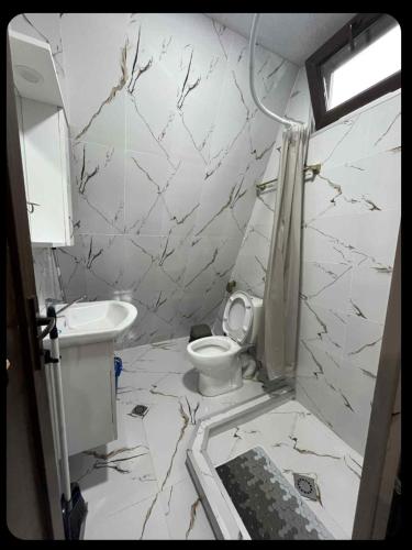 a white bathroom with a toilet and a sink at LUNEA cottage in Machakhlispiri