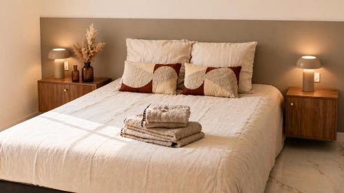 a bedroom with a white bed with towels on it at Résidence Bozzi in Grosseto-Prugna