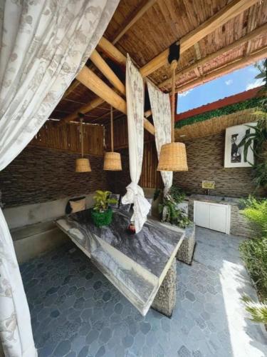 a patio with a table and chairs and a ceiling at Charming House with Private Pool in Bacolod