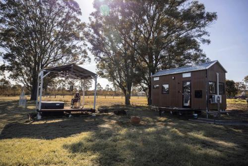 a man standing next to a tiny house at Odyssean Tiny House B by Tiny Away in Cessnock
