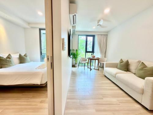 a bedroom and living room with a bed and a couch at Skypark Laguna Phuket by Escape Villas in Laguna Phuket