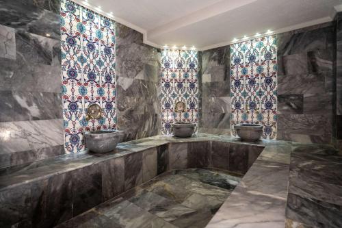 ein Zimmer mit drei Töpfen an einer Wand mit Buntglasfenstern in der Unterkunft Ugurlu Hotel in Gaziantep