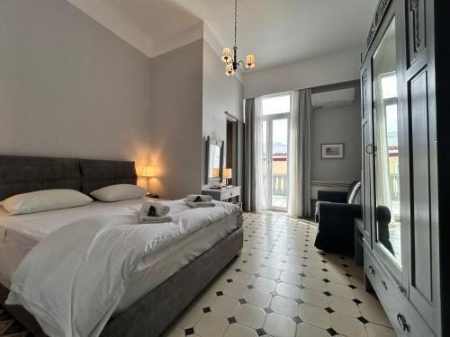 a bedroom with a bed and a large window at Tinion Hotel in Tinos