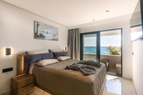 a bedroom with a bed with a view of the ocean at Black Rocks Family Beach Resort in Agios Gordios